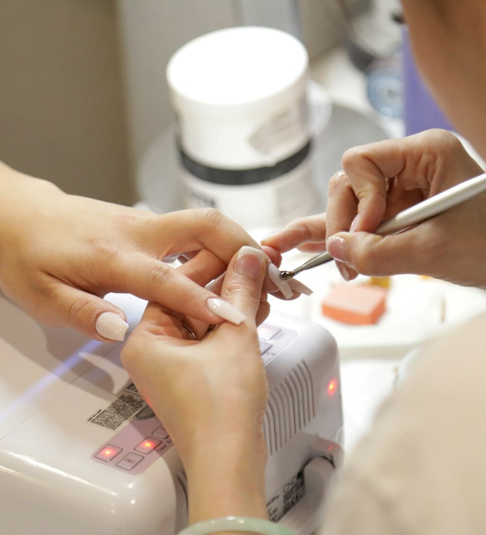 Nail designer aplicando alongamento de unhas em uma cliente
